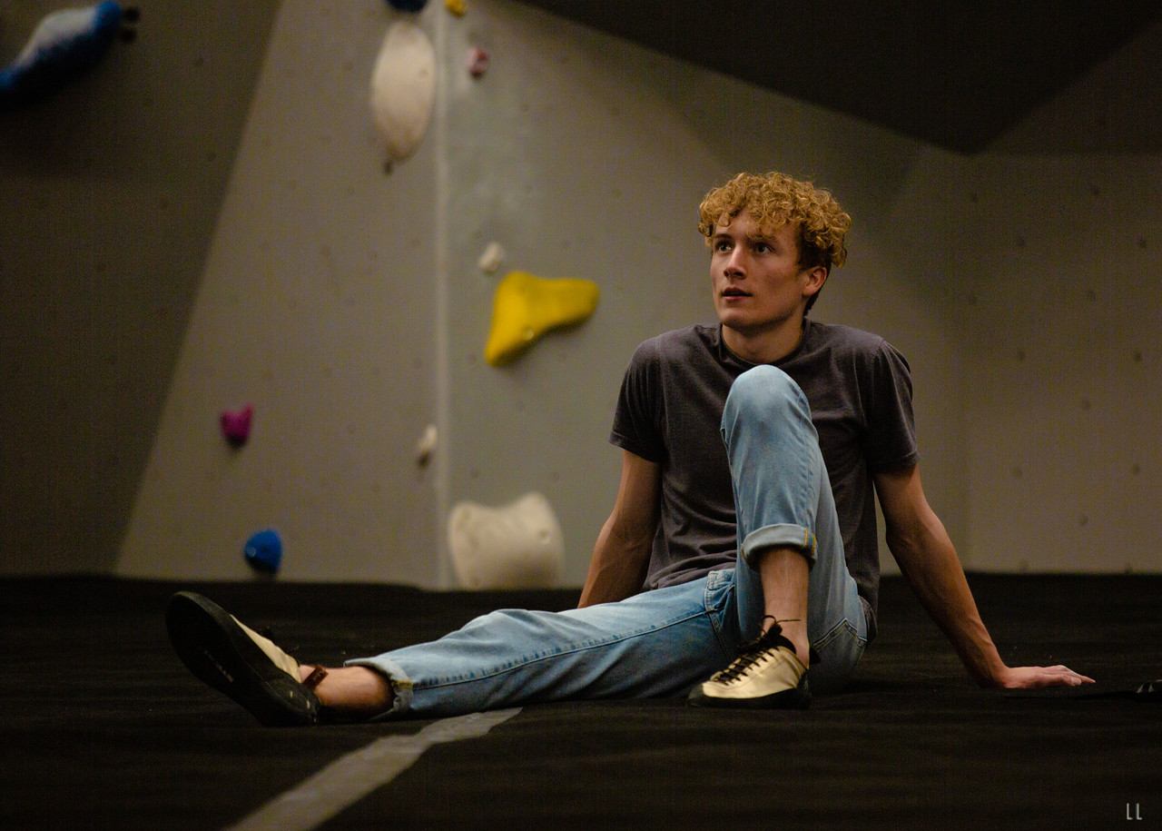 A young man sitting on the mat at The Climbing Hangar