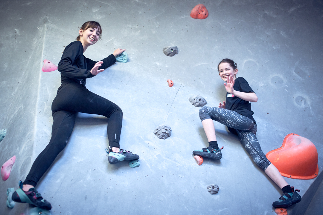 Two girls balancing on a climbing wall