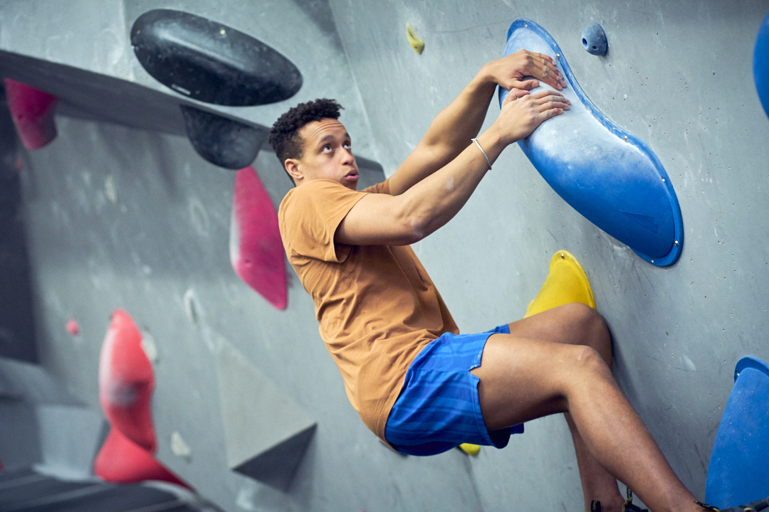 A man pulling onto a climbing wall