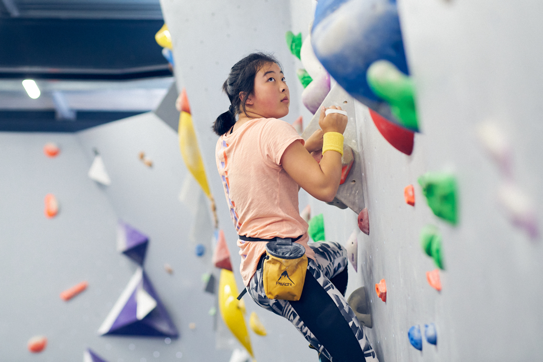 A woman climbing at The Climbing Hangar