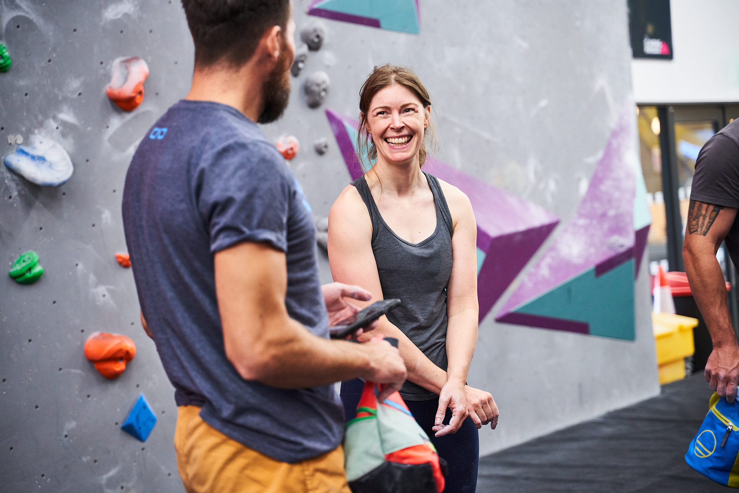 A woman smiling at her male friend at The Climbing Hangar