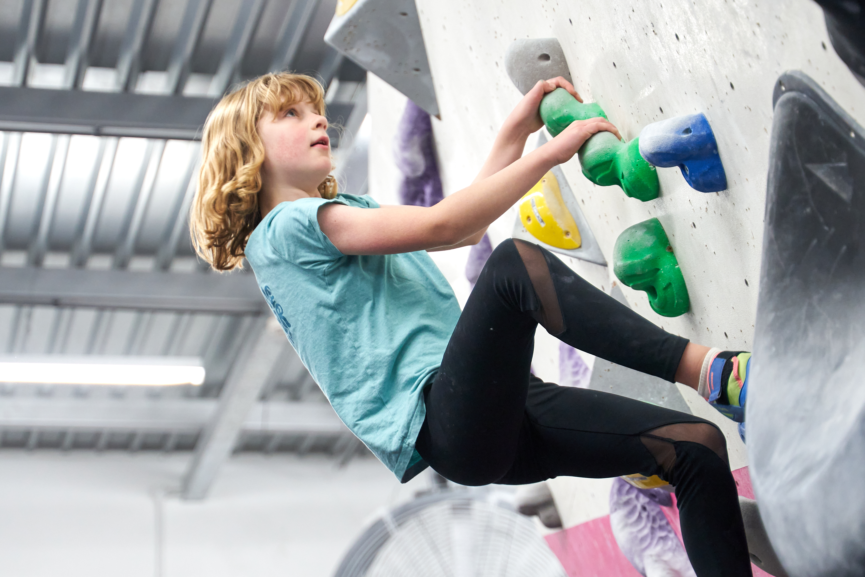 A young climber gets to grips with the wall.